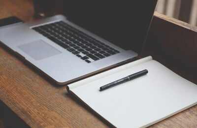 Notizheft und Laptop
