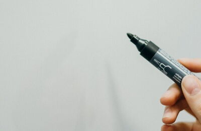 Hand hält einen Stift auf
